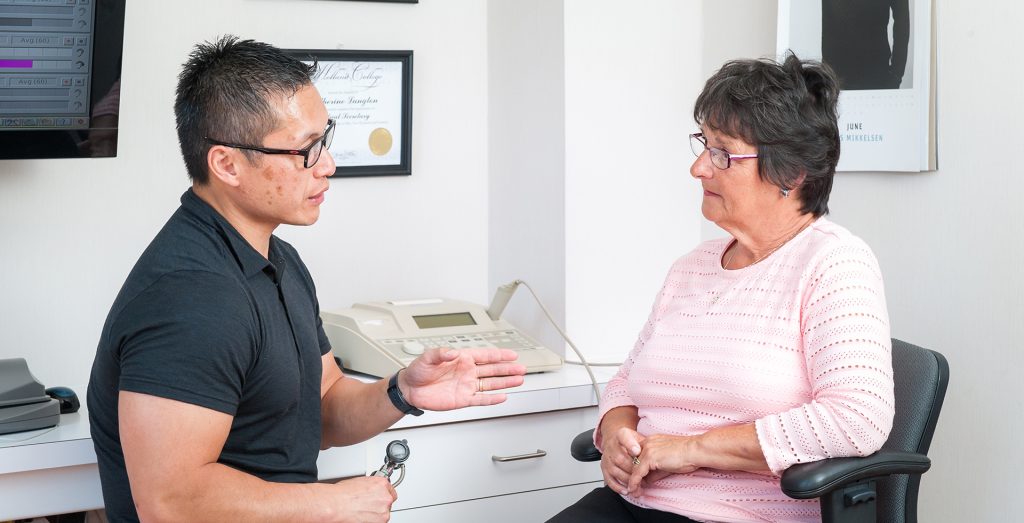 Steve Wong explaining how hearing works to a patient